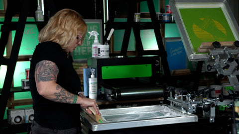 seorang wanita berambut pirang menekan layar dengan penyapu tinta putih