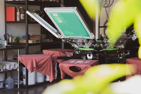 Mesin cetak manual dengan semua layar dimuat dan kemeja di semua pelat cetak