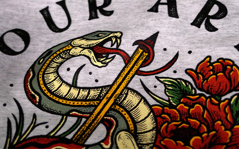 seekor ular memegang layar dengan panah tercetak di kaos abu-abu