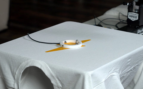 kaos putih dengan gambar petir kuning dan probe donat ditempatkan di lapisan tinta